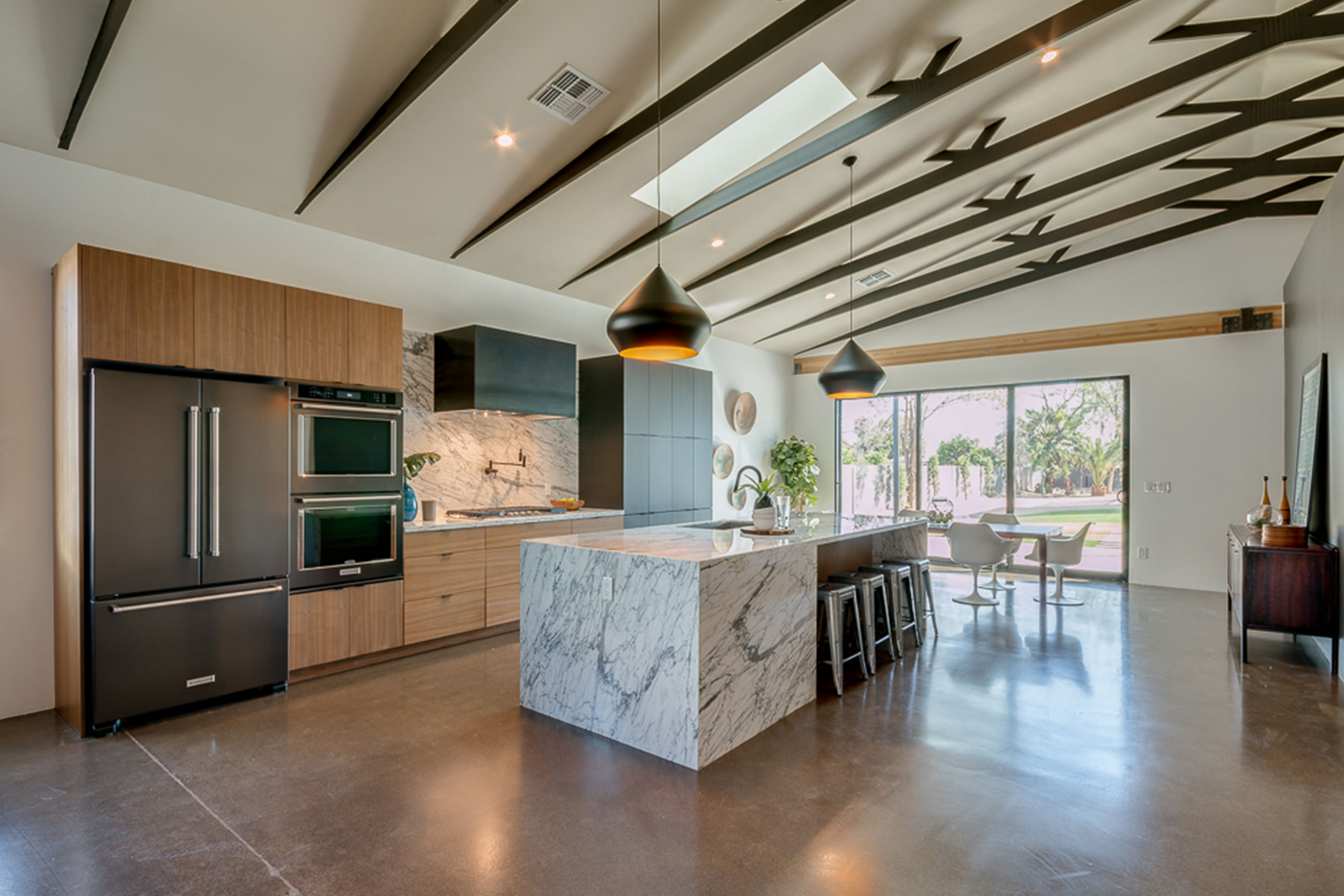 Modern open concept kitchen with 20ft ceiling at center of vault, exposed structural scissor trusses in Phoenix, AZ