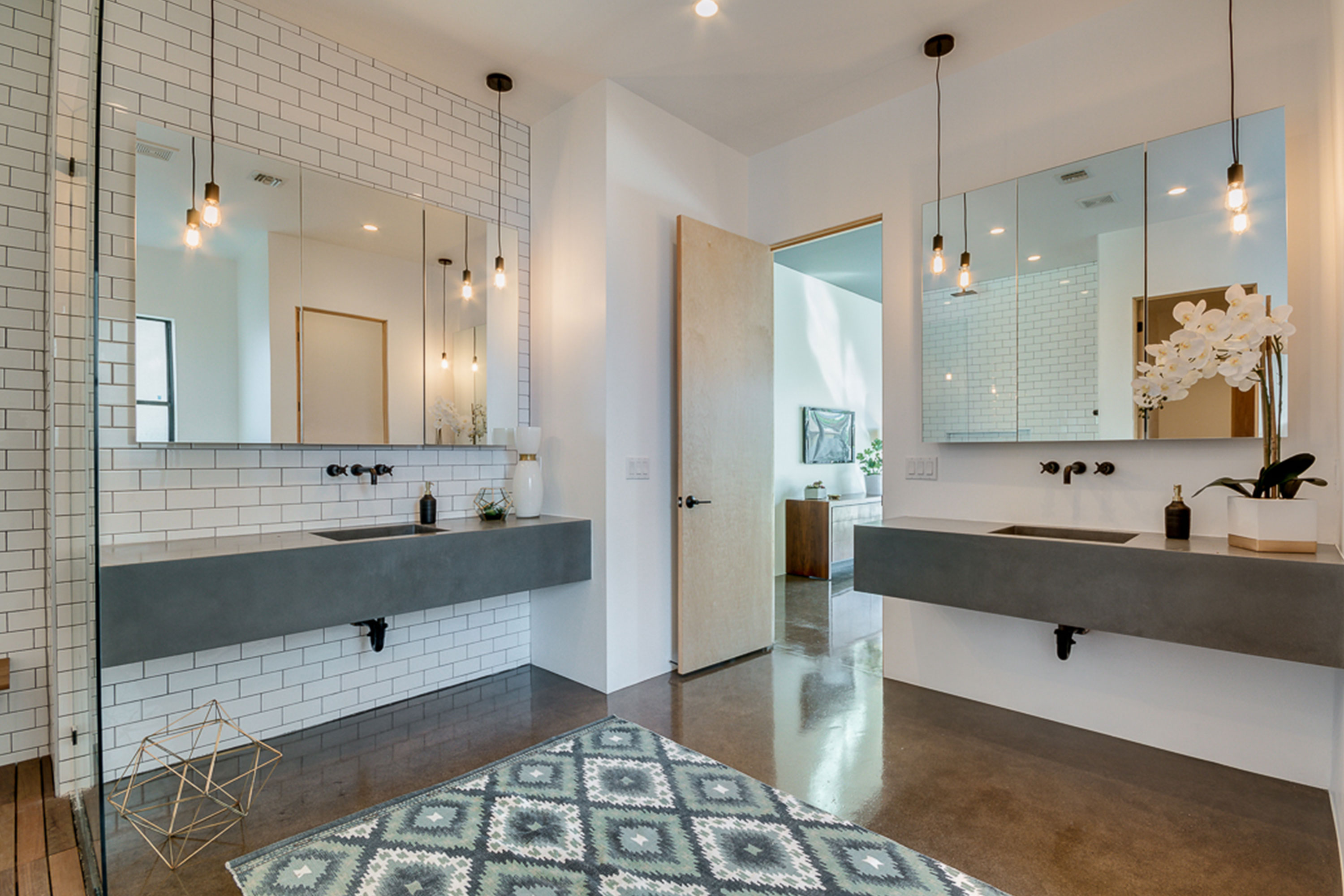 Master bathroom with polished concrete floors, American Walnut cabs, Valentino Marble, his and hers concrete master vanities