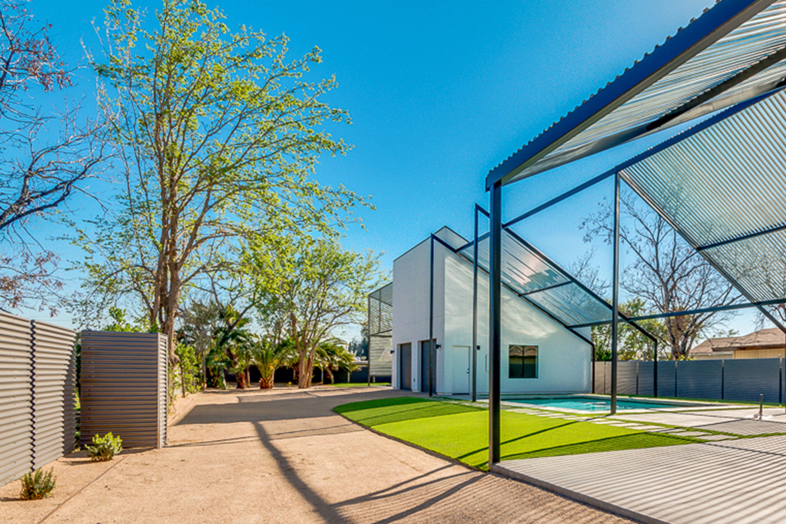 Coronado Historic District home with expansive backyard that showcases a large pool surrounded with turf beneath a steel trellis