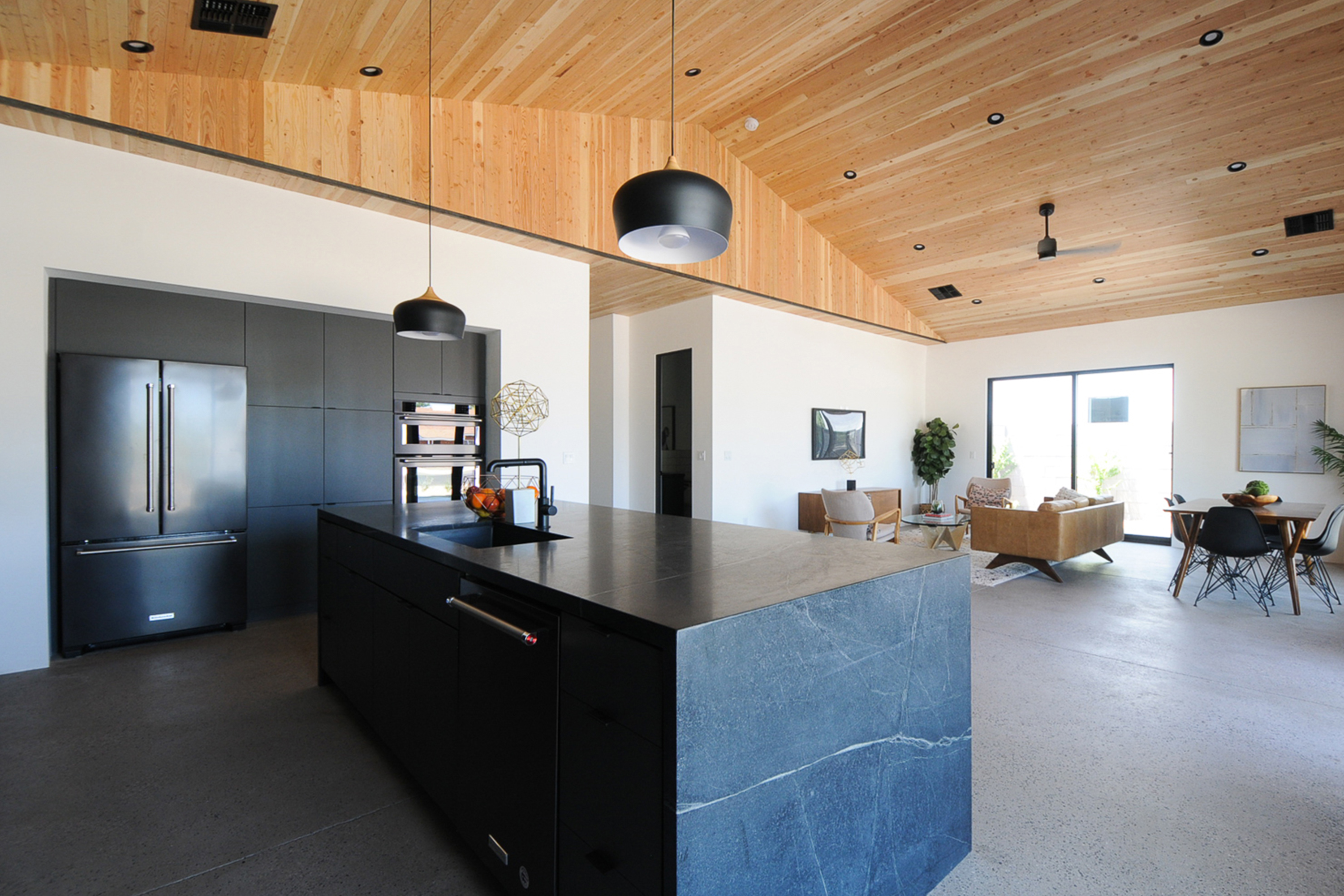 Open concept bali style kitchen and livingroom with wood clad vaulted ceilings