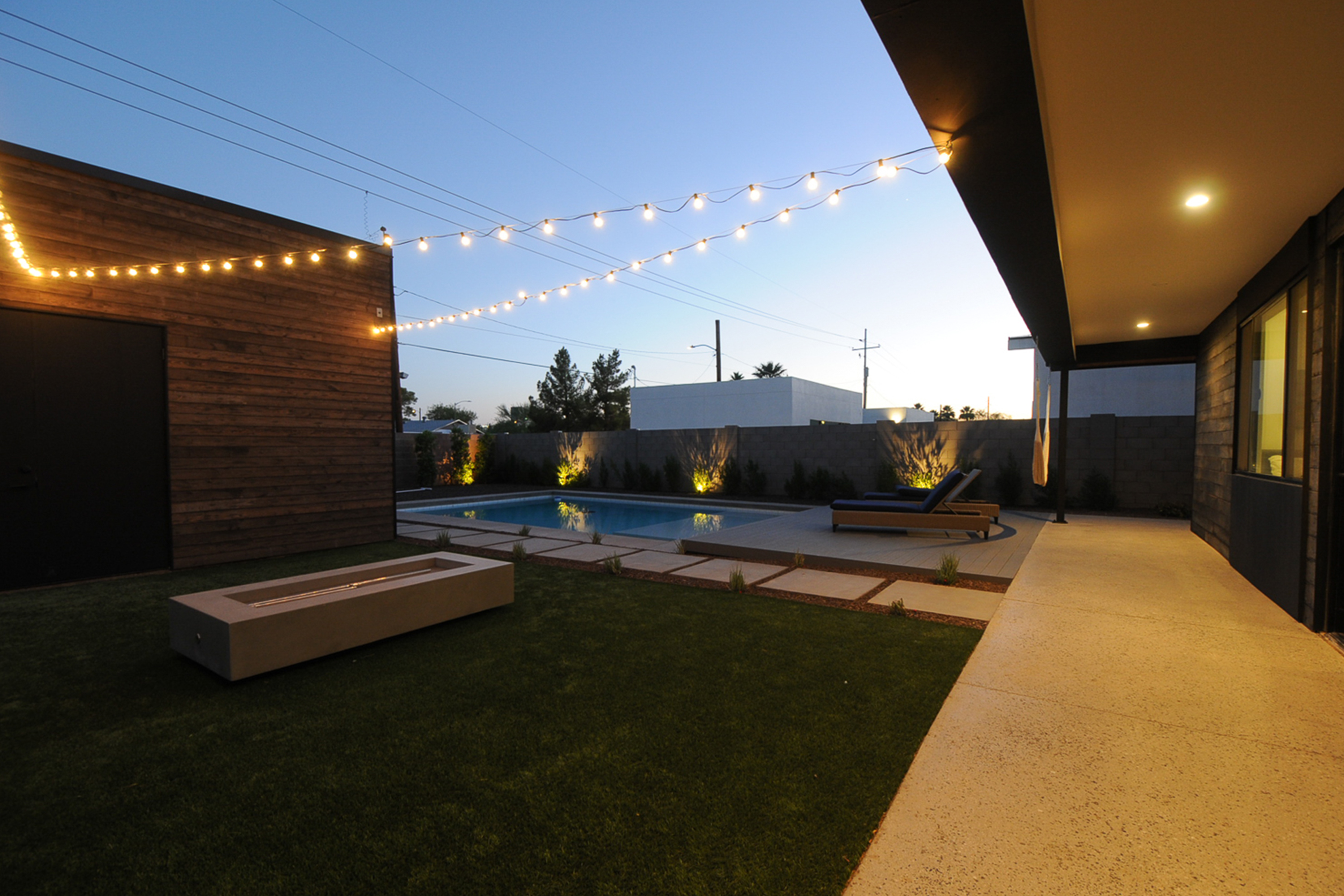 massive pool with Baja shelf and a large Trex deck and gas concrete firepit complemented by synthetic gras